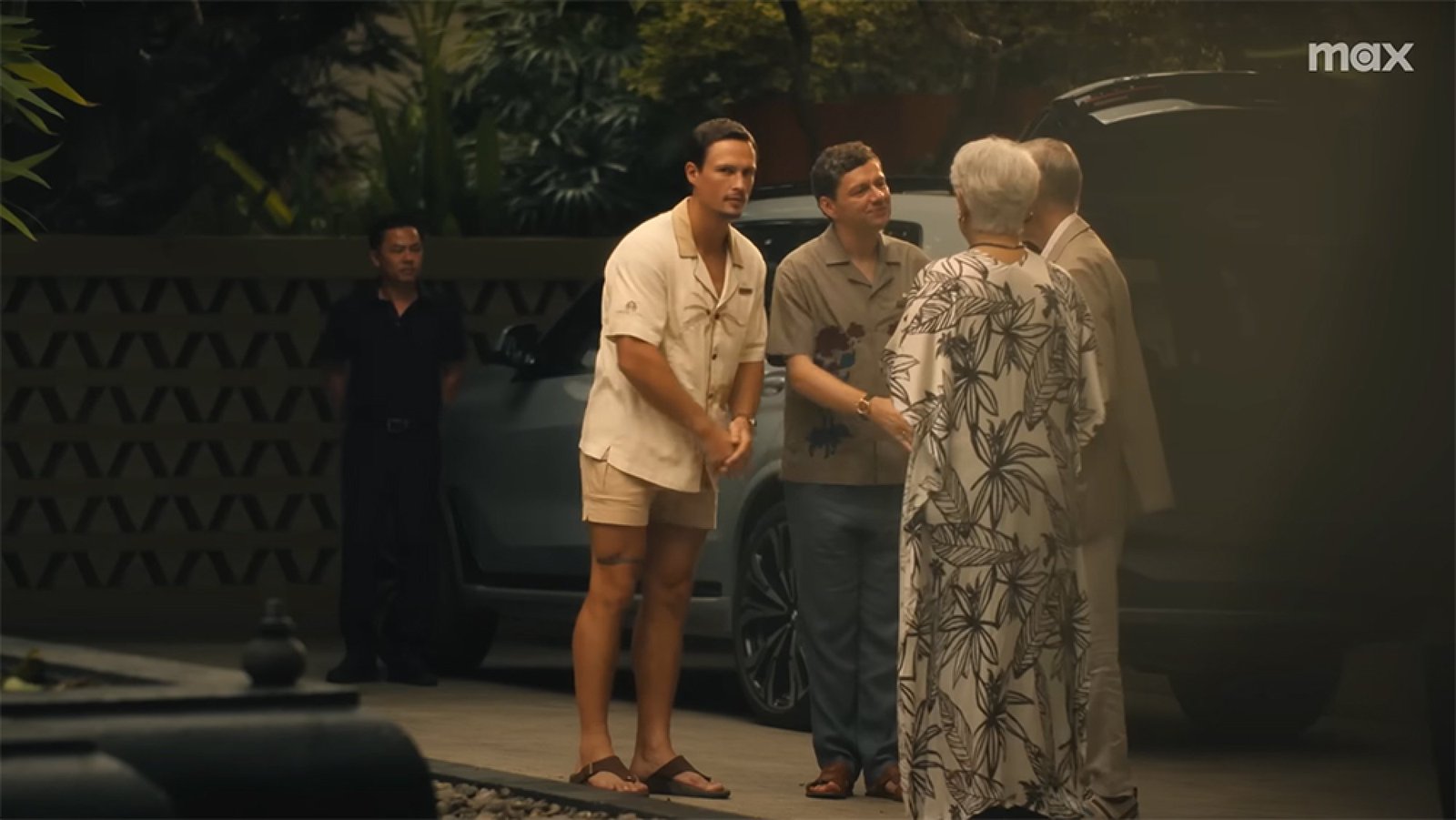 A group of people stand outside greeting each other.