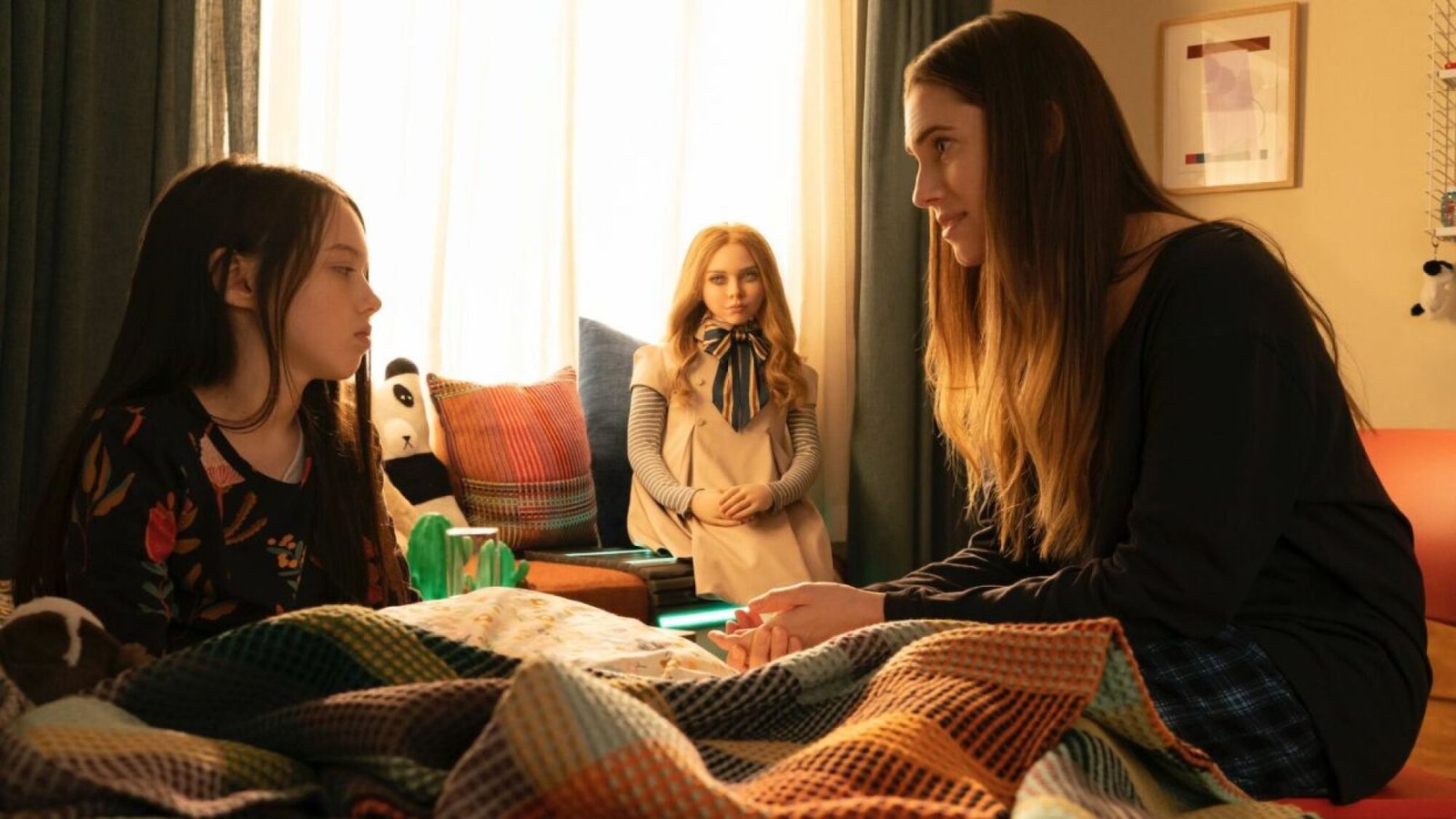 images-3-fill_-size_2000x1125-v1687977147 A woman speaks to a young girl while sitting in her bedroom. A doll sits between them.