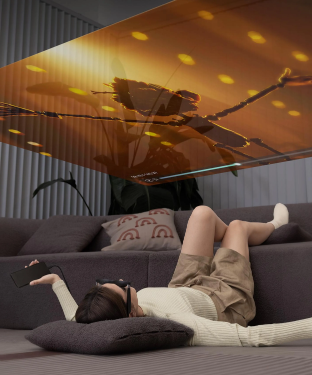 Person laying on floor watching screen displayed onto ceiling using AR glasses